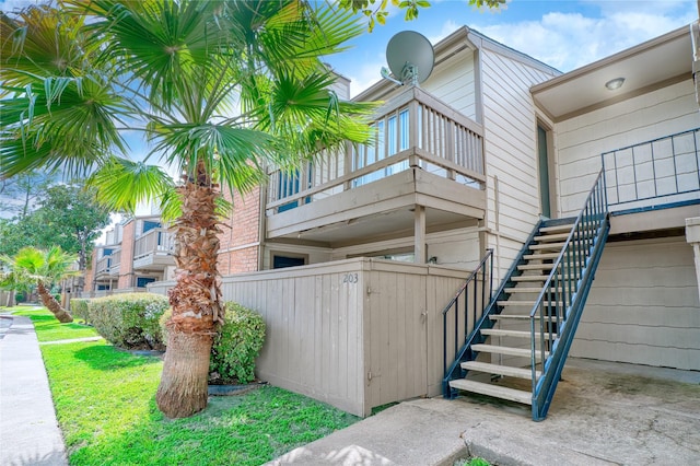 view of property exterior with fence and stairs