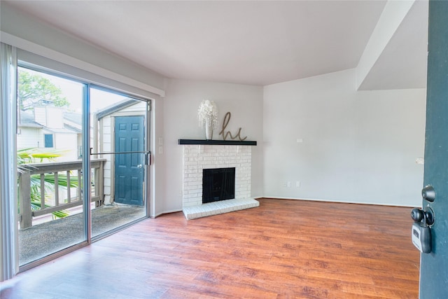 unfurnished living room with a fireplace, wood finished floors, and a healthy amount of sunlight