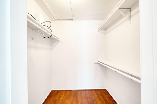 spacious closet with wood finished floors and attic access