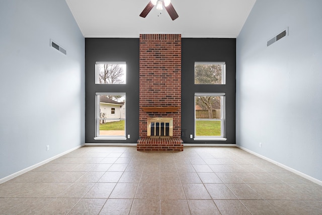 unfurnished living room with a healthy amount of sunlight, a brick fireplace, visible vents, and crown molding