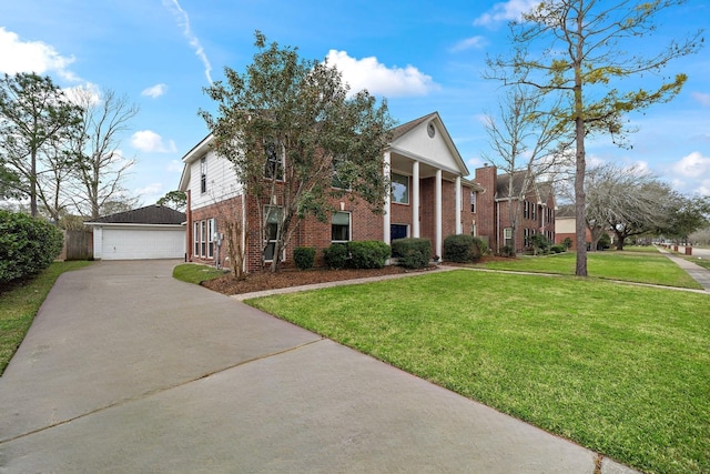 greek revival house featuring an outbuilding, brick siding, a front lawn, and a detached garage