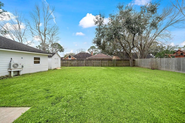 view of yard featuring an outbuilding, a fenced backyard, and a storage shed