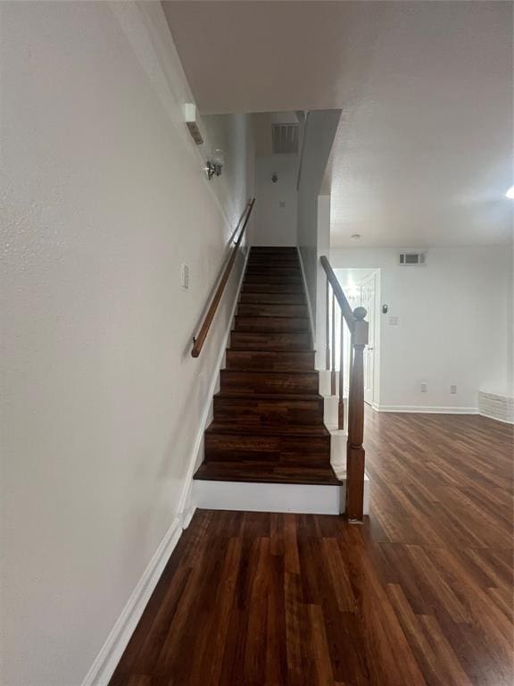 stairs with visible vents, baseboards, and wood finished floors