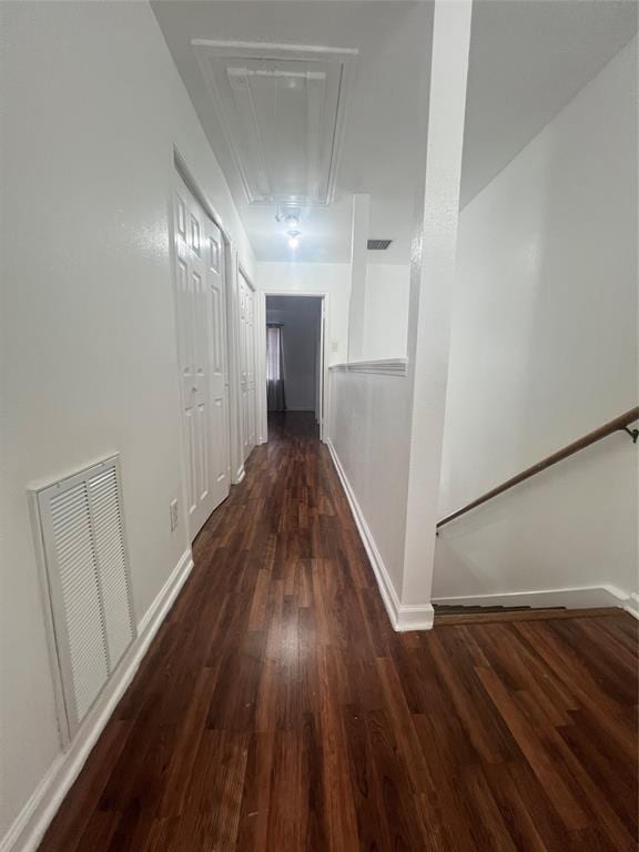 hall featuring visible vents, wood finished floors, attic access, and baseboards