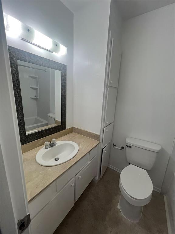 bathroom featuring baseboards, vanity, and toilet