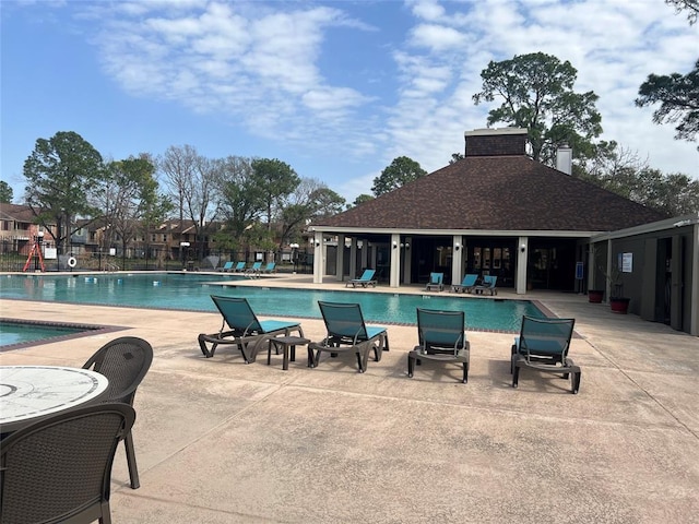 community pool featuring fence and a patio