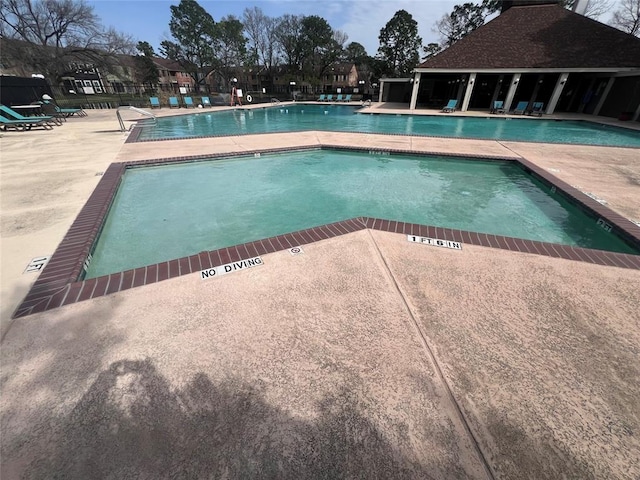 pool with a patio and fence