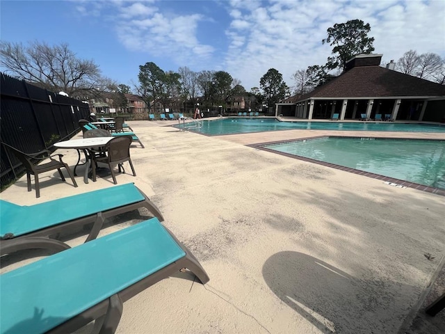 community pool featuring a patio area and fence