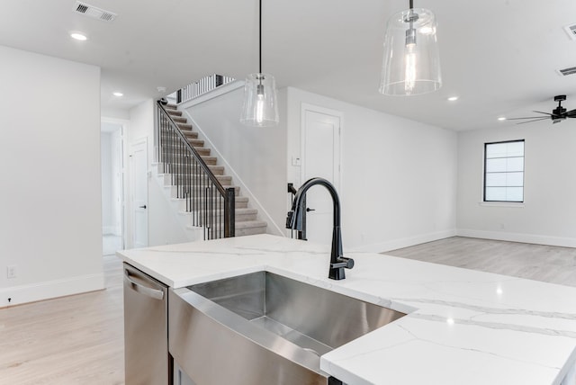 kitchen with visible vents, light wood-style flooring, stainless steel dishwasher, open floor plan, and a sink