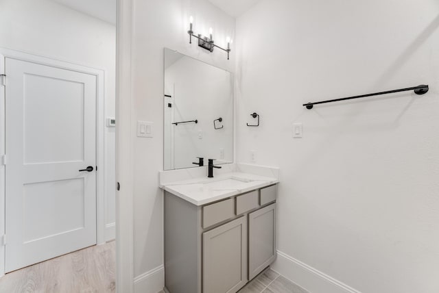 bathroom featuring vanity, baseboards, and wood finished floors