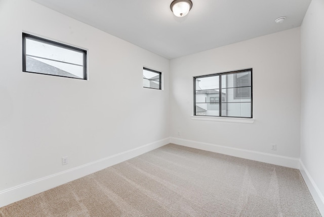 carpeted spare room featuring baseboards