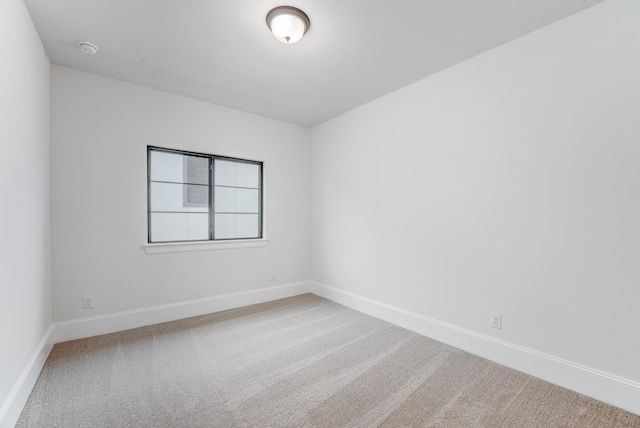 carpeted spare room with baseboards