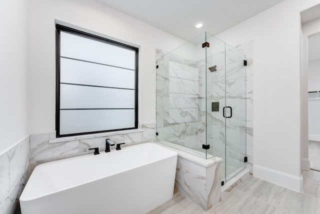 full bathroom with a soaking tub, a marble finish shower, tile walls, and recessed lighting