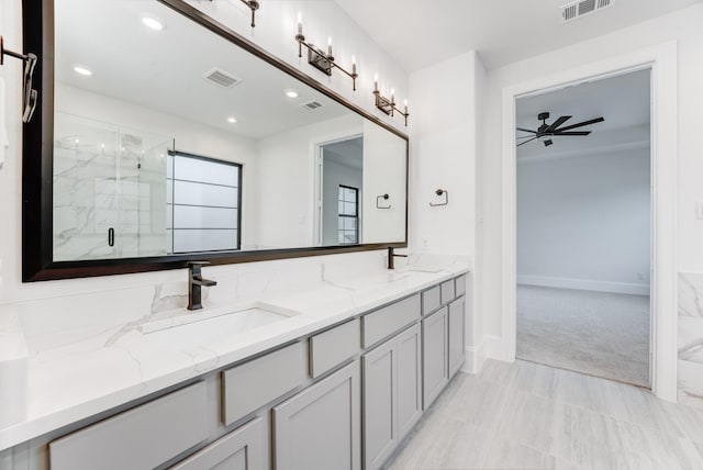 bathroom featuring a marble finish shower, visible vents, and a sink