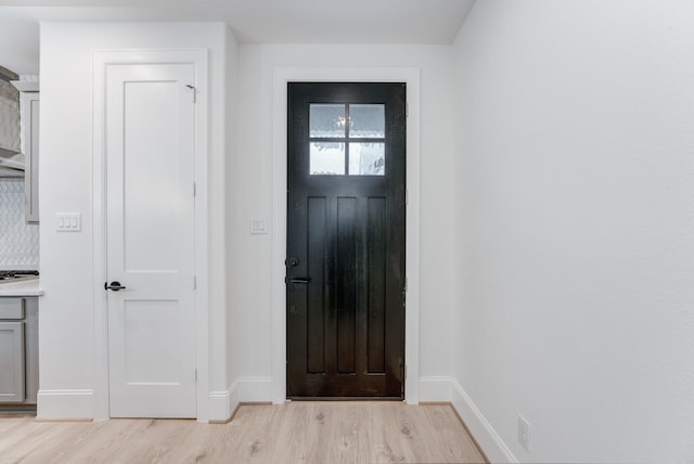 foyer entrance featuring light wood-style flooring and baseboards