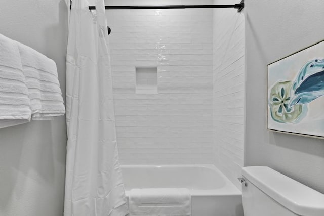 bathroom featuring shower / tub combo and toilet