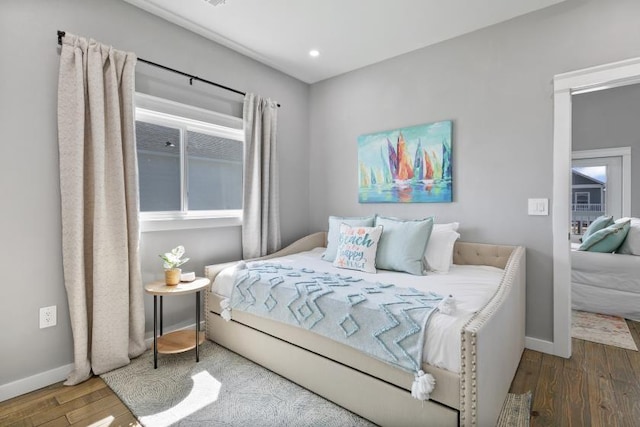 bedroom featuring baseboards, wood finished floors, and recessed lighting