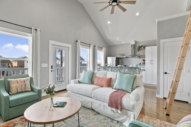 living room with high vaulted ceiling, recessed lighting, a ceiling fan, and light wood-style floors