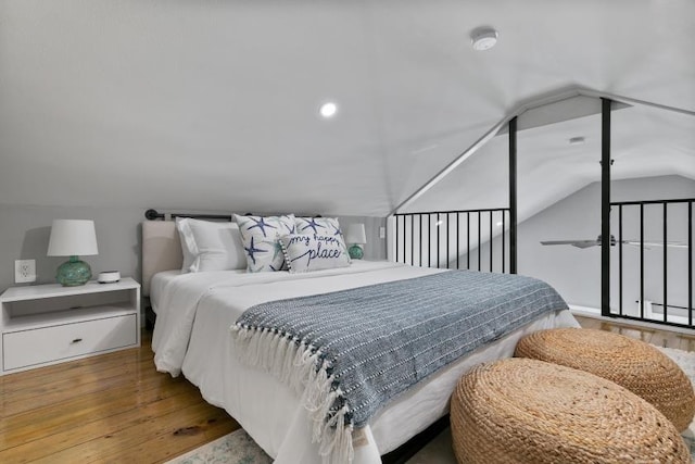 bedroom with lofted ceiling and wood-type flooring