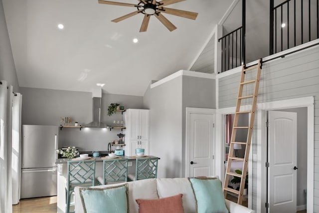 kitchen with open shelves, lofted ceiling, freestanding refrigerator, white cabinets, and wall chimney exhaust hood