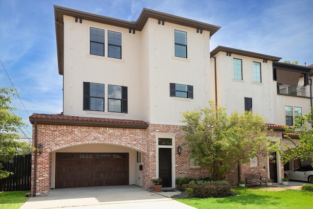 view of front of home with brick siding, driveway, an attached garage, and stucco siding