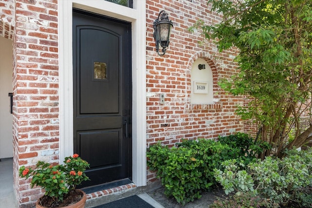 doorway to property featuring brick siding