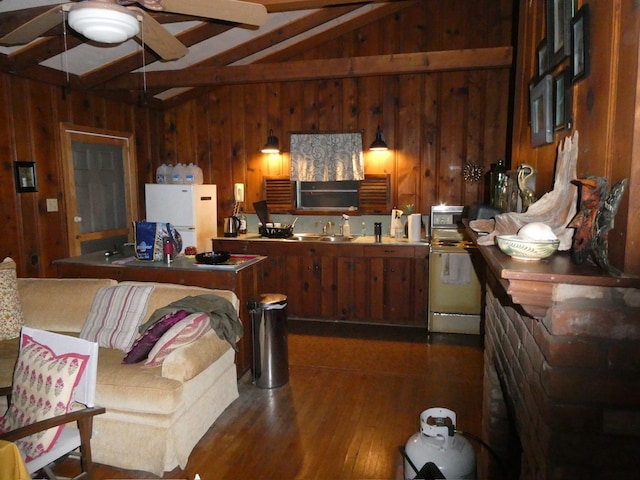 kitchen featuring freestanding refrigerator, wood walls, lofted ceiling with beams, and a sink