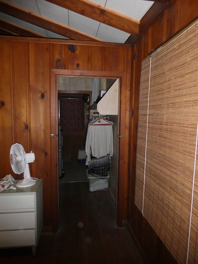 corridor with wood walls and beam ceiling