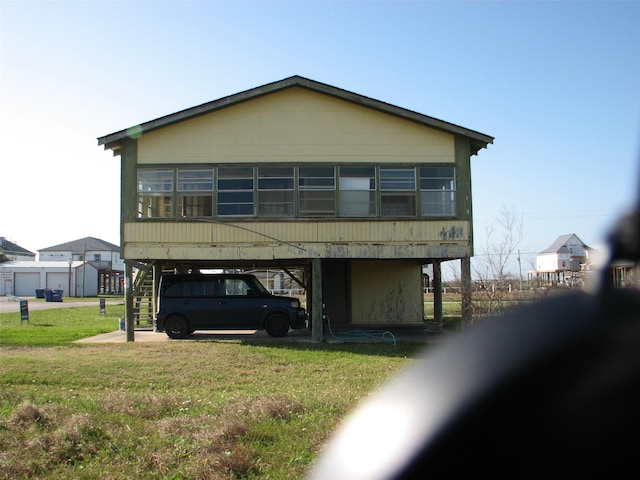 view of front of property featuring a carport, a front lawn, and stairway