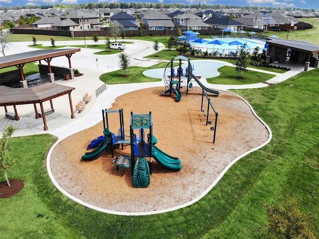 exterior space featuring playground community, a yard, and a residential view