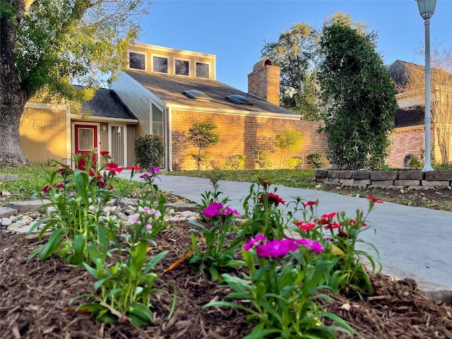 view of front of home with brick siding and a chimney