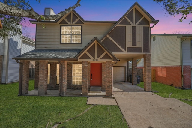 view of front of property with driveway, a garage, fence, a yard, and brick siding