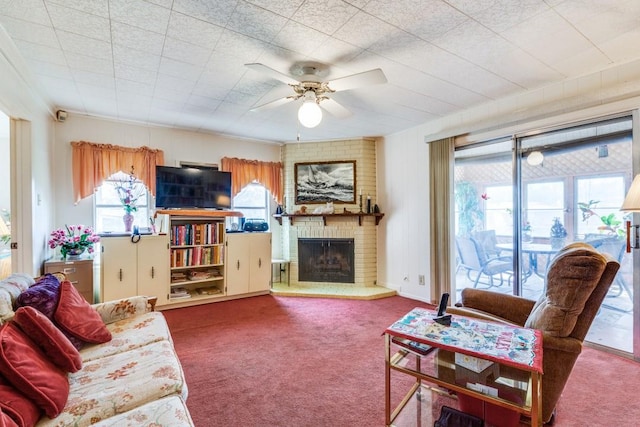 carpeted living area with a ceiling fan, a wealth of natural light, and a brick fireplace