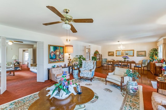 living room with carpet flooring and ceiling fan with notable chandelier