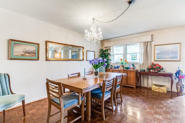 dining room with baseboards and a notable chandelier