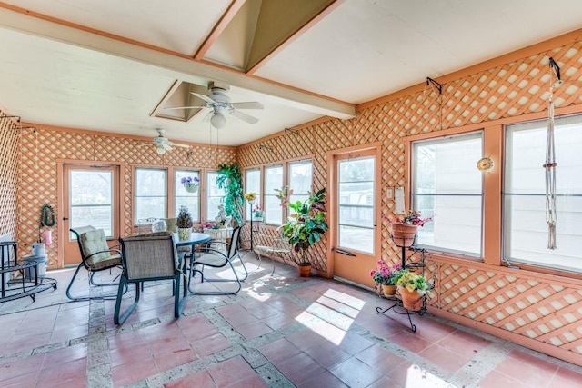 sunroom featuring a ceiling fan and beamed ceiling