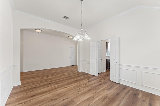 unfurnished dining area featuring ornamental molding, visible vents, a notable chandelier, and light wood-style flooring