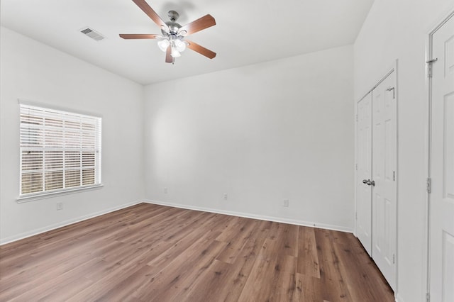 unfurnished bedroom with visible vents, baseboards, and wood finished floors