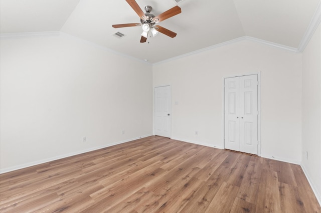 unfurnished bedroom featuring ornamental molding, visible vents, vaulted ceiling, and light wood-style flooring