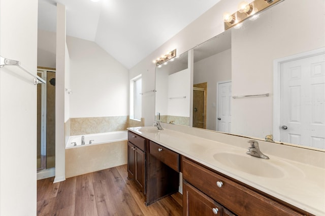 full bathroom featuring a bath, a stall shower, vaulted ceiling, and a sink