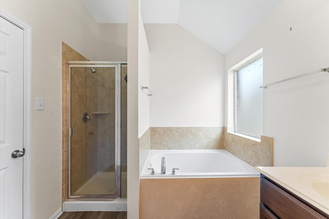 bathroom with lofted ceiling, a shower stall, vanity, and a bath