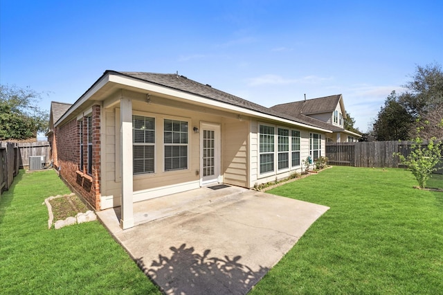 back of property featuring brick siding, a lawn, a patio area, cooling unit, and a fenced backyard