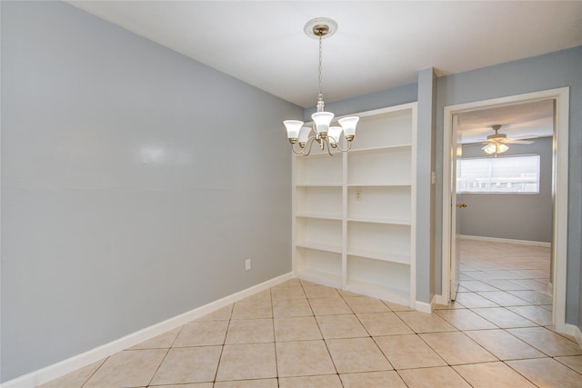 unfurnished dining area with light tile patterned floors, baseboards, and ceiling fan with notable chandelier