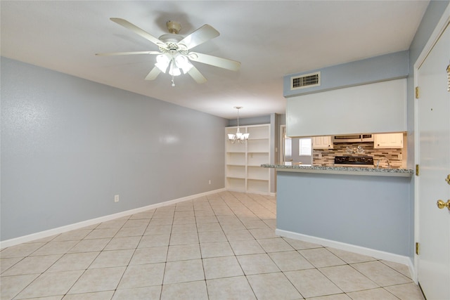 spare room featuring light tile patterned floors, visible vents, baseboards, and ceiling fan with notable chandelier