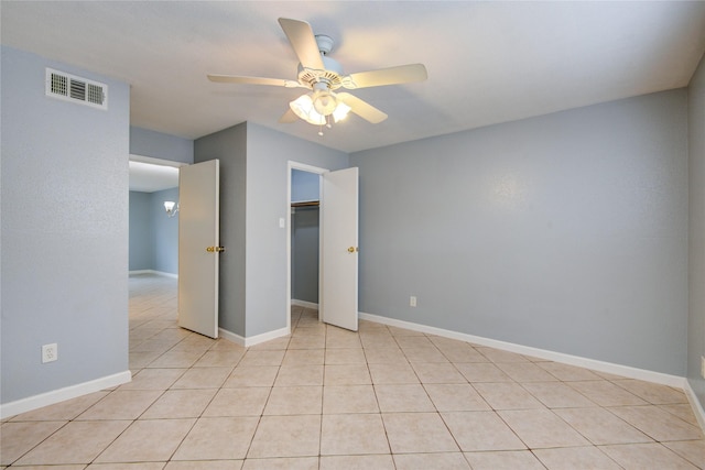 unfurnished bedroom with light tile patterned floors, a closet, visible vents, ceiling fan, and baseboards