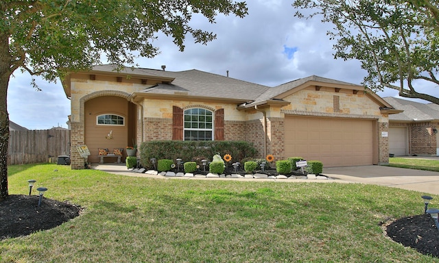 view of front of property featuring brick siding, a front lawn, an attached garage, and fence