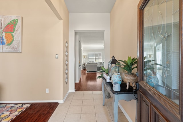 hall with baseboards and light tile patterned floors