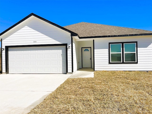 single story home with a garage, driveway, a shingled roof, and a front yard