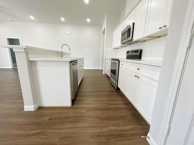 kitchen with recessed lighting, a sink, appliances with stainless steel finishes, decorative backsplash, and dark wood-style floors