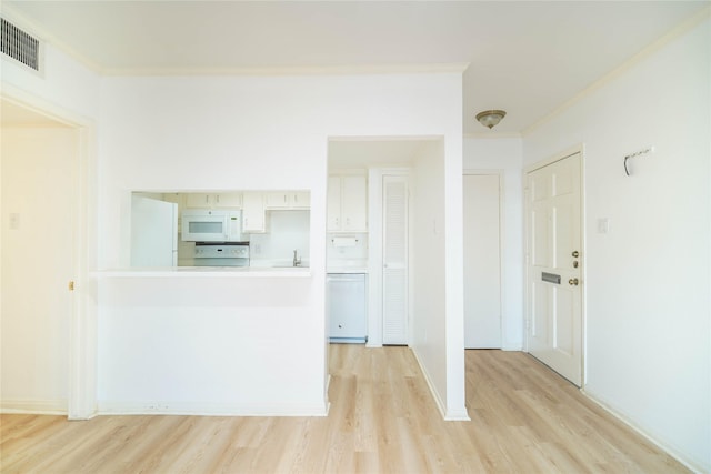 interior space with light wood-style flooring, visible vents, and crown molding